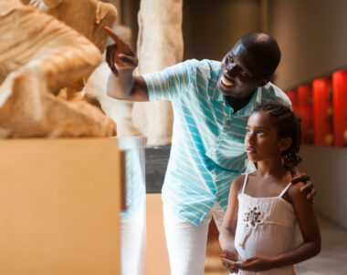 A young father and his daughter curiously point at an exhibit at one of the many museums in Charleston, SC.